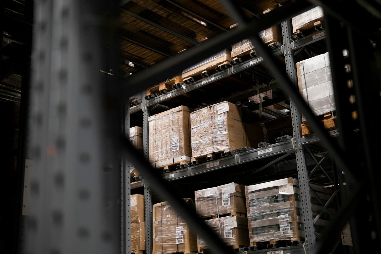Tarimas emplayadas y etiquetadas apiladas en racks de almacén, el tipo de inventario de importación temporal que ampara un programa IMMEX