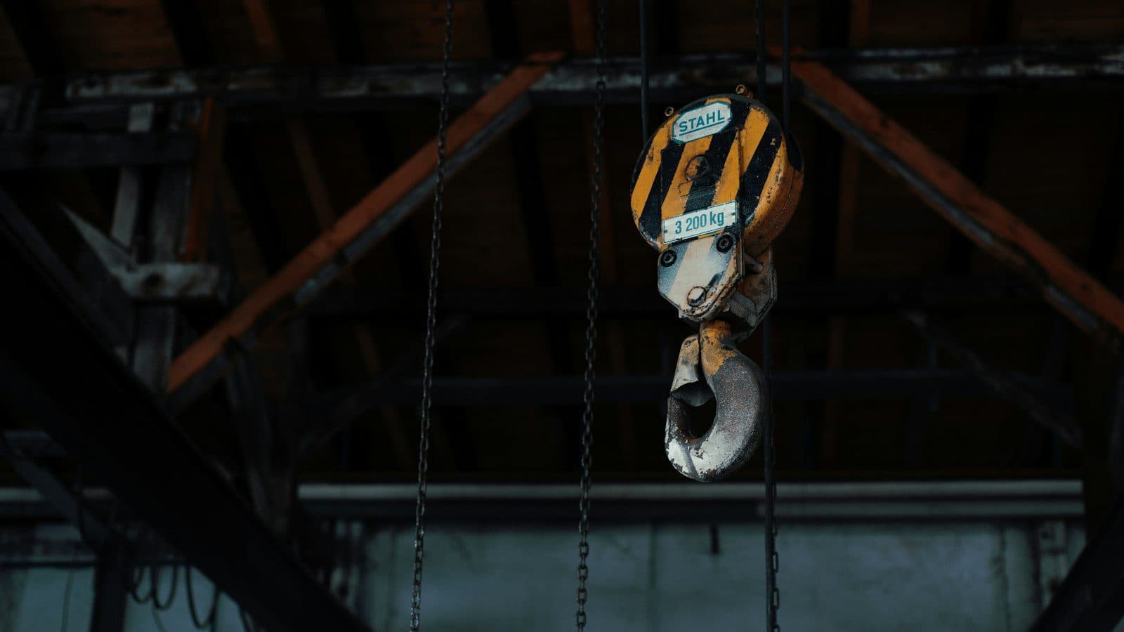 An overhead crane hook rated at 3,200 kg hanging in a factory bay, the kind of lift a production line depends on when its machines are crated, moved across the border and set again on a Mexican floor