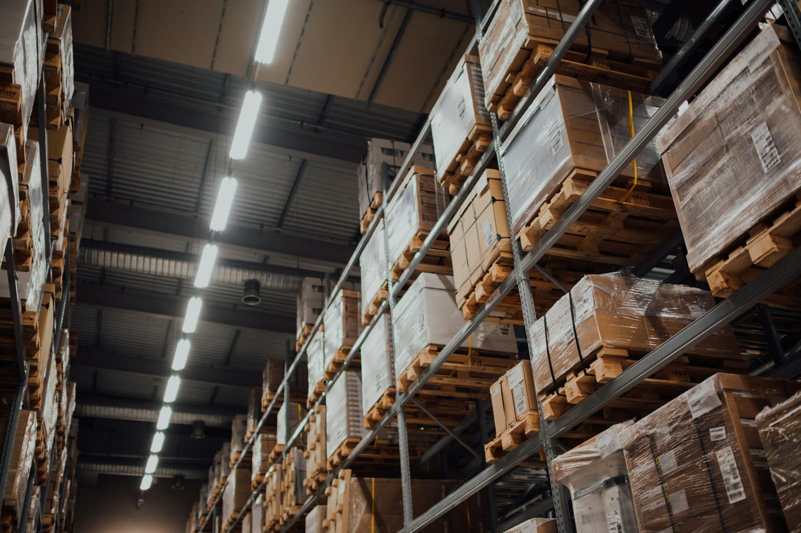 Rows of pallet racking stacked with shipping boxes in a large distribution warehouse, illustrating Mexico's nearshoring-driven supply chain and logistics growth in 2026
