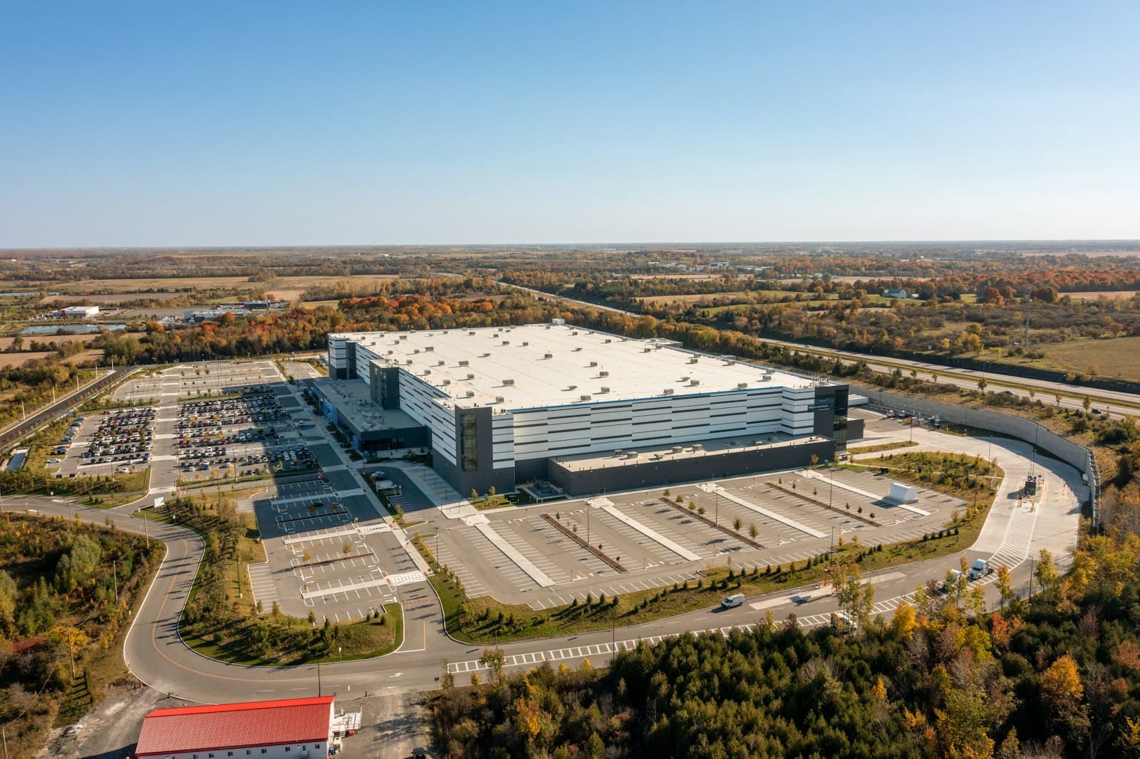 Aerial view of a large modern distribution warehouse and its industrial park with expansive parking, the kind of shelter-operated industrial real estate found across Mexico