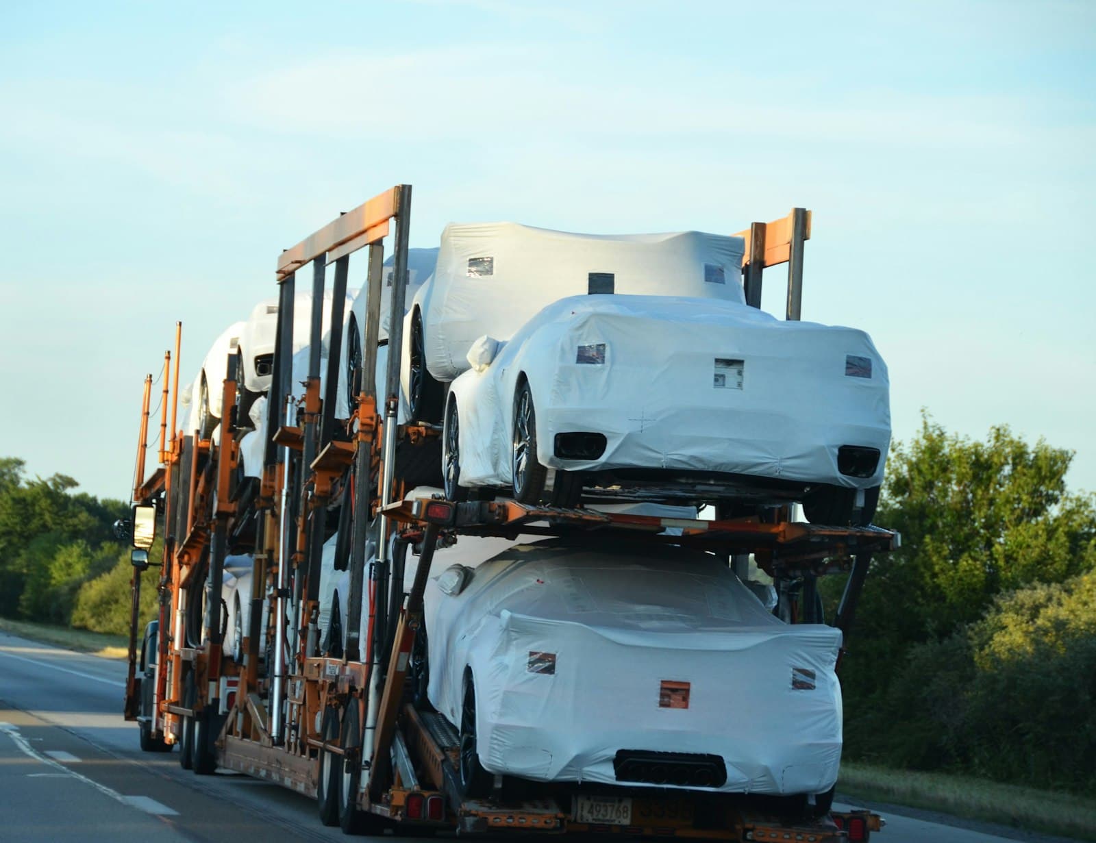 Wrapped new vehicles stacked on a car carrier travelling a highway, the moment a declared content figure becomes a duty