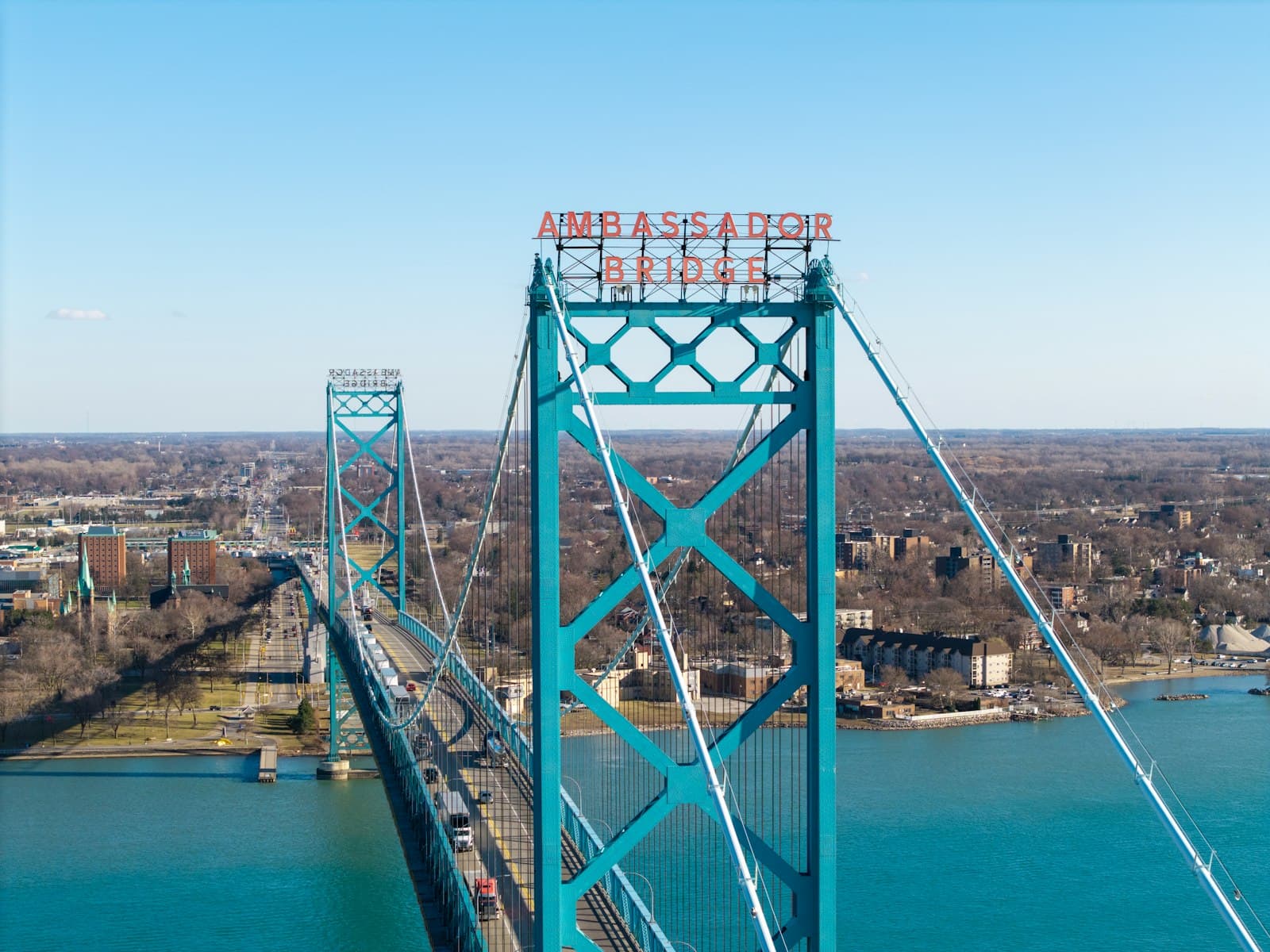 Trucks crossing the Ambassador Bridge between Windsor, Ontario and Detroit, Michigan, the busiest commercial crossing on the Canada-US border, where every Canadian-made good meets the 2026 US tariff stack