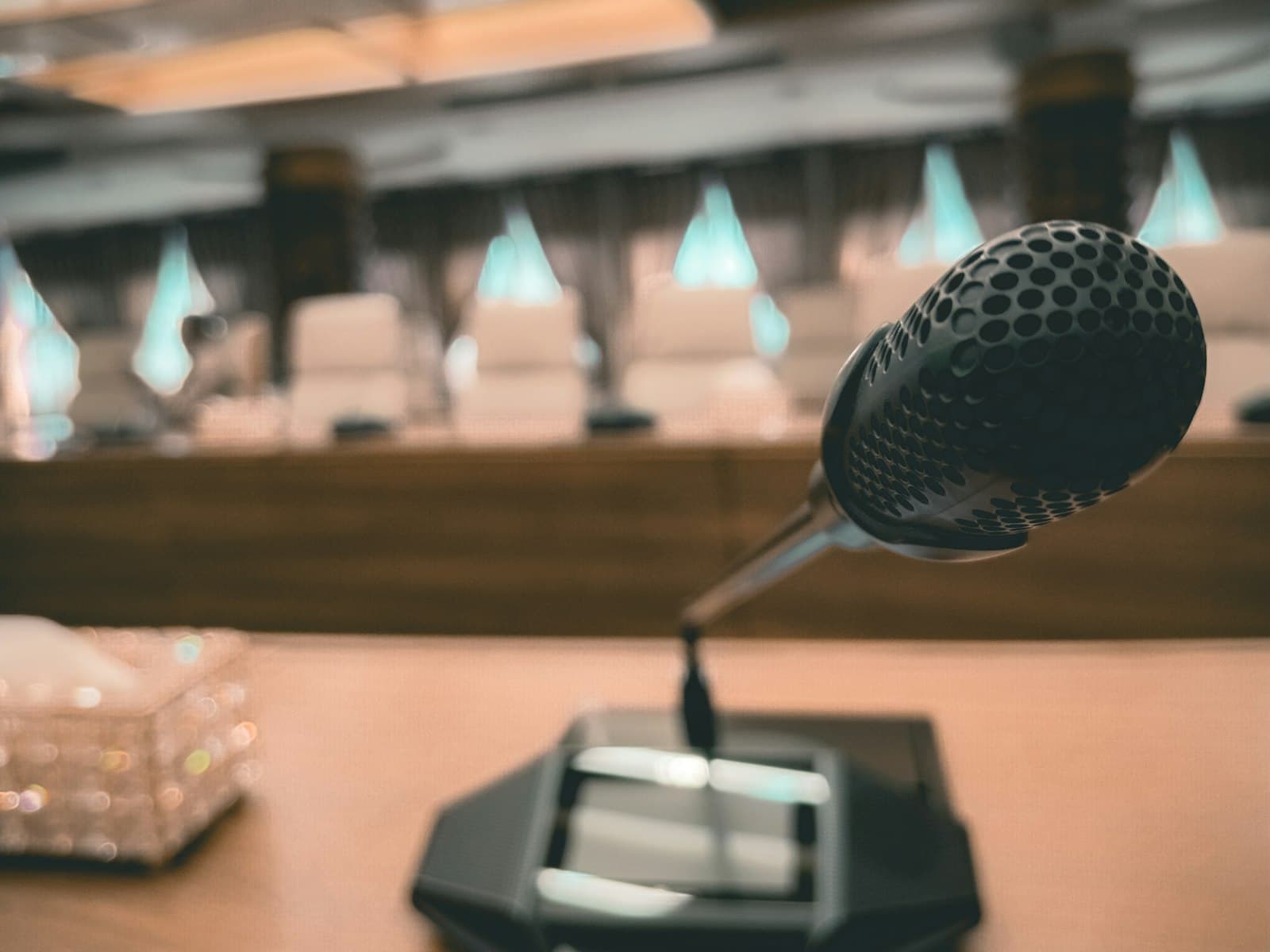 Primer plano de un micrófono de delegado en una mesa de conferencias vacía en una sala de negociación formal antes de la segunda ronda bilateral del T-MEC